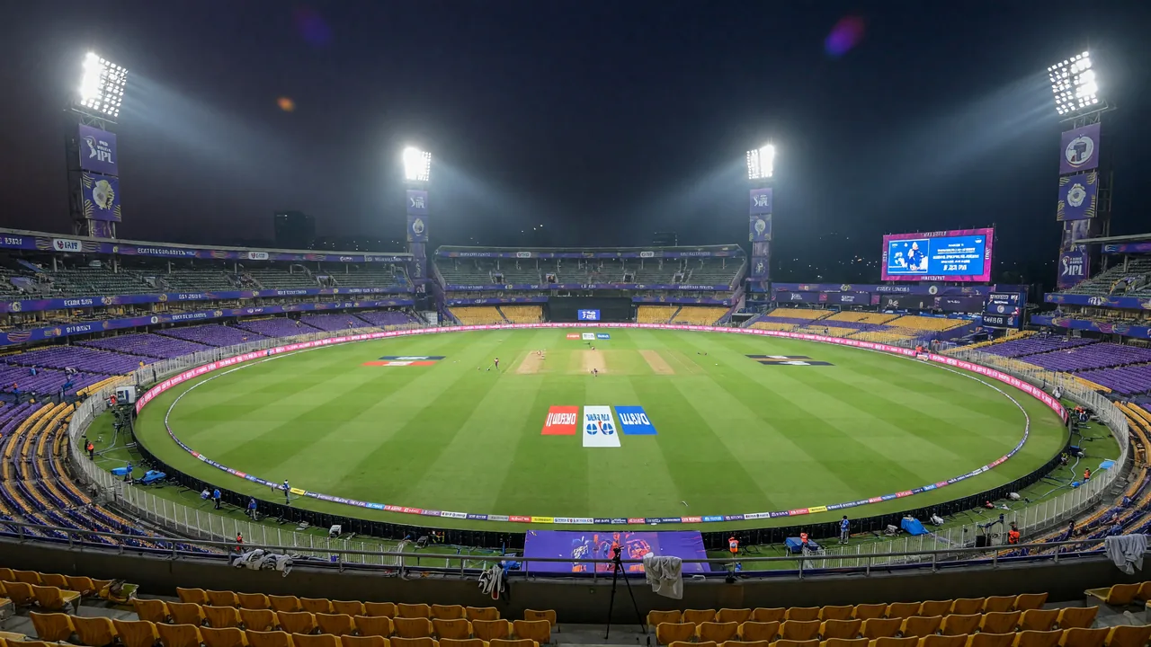 An evening cricket stadium under floodlights with the scoreboard visible at the top of the frame